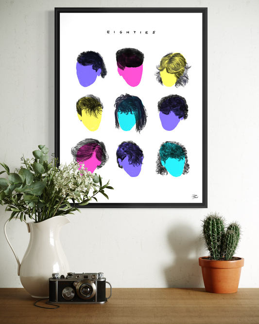 EIGHTIES framed art print showing a colorful 3x3 grid of nine iconic 1980s haircut silhouettes in a minimalist modern studio. The print hangs above a white desk with books and a large potted Monstera plant. A museum-quality artifact by Vaykay-Idanshani.